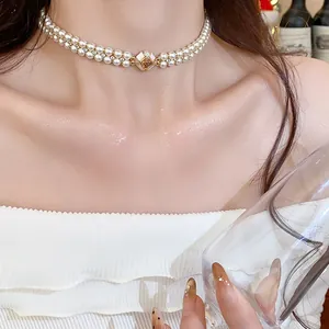 Detailed view of an elegant double-strand pearl choker with a golden zircon center
