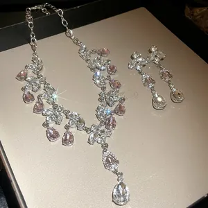 Gros plan d'un collier élégant à pampilles en strass avec boucles d'oreilles assorties.