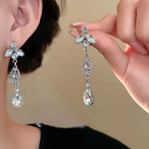 Vue détaillée d'élégantes boucles d'oreilles pendantes en strass feuille et goutte