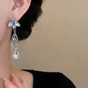 Vue détaillée de boucles d'oreilles élégantes en feuille d'argent et goutte de cristal