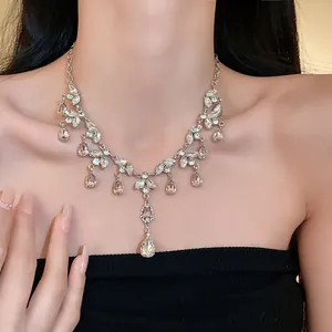 Gros plan d'un collier à pompons feuilles et gouttes d'eau sur le cou d'un modèle