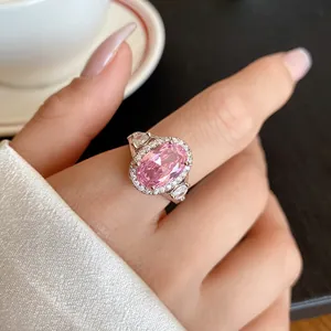 Primo piano dell'anello scintillante con zircone rosa ovale e contorno di pietre