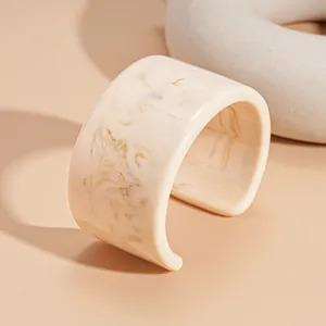Close-up of irregular resin cuff bracelet with beige marble texture and vintage design