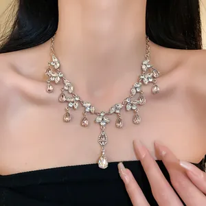 Gros plan détaillé d'un élégant collier à pampilles en feuilles d'argent et gouttes de strass.
