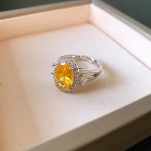 Primo piano di un elegante anello d'argento con un grande zircone giallo e cristalli