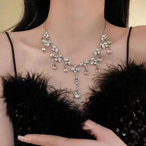 Gros plan d'un collier élégant à pampilles de feuilles et de gouttes sur un mannequin.