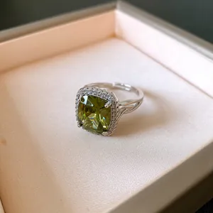 Primo piano di un elegante anello d'argento con zircone verde e pietre di contorno