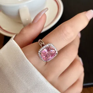 Dettaglio macro di un anello di lusso con zircone rosa, alone scintillante e fascia in argento