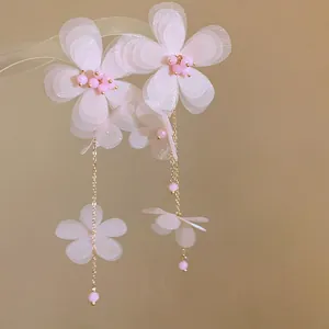 Primo piano di eleganti orecchini a nappa con fiori in chiffon rosa