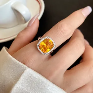 Vista dettagliata di anello in argento con grande zircone giallo e pietre di halo