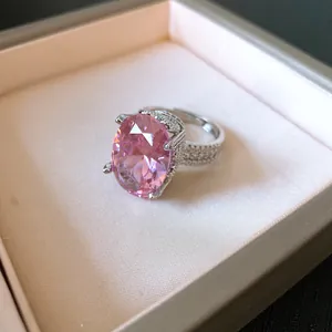 Primo piano di un elegante anello aperto in argento con grande pietra rosa ovale