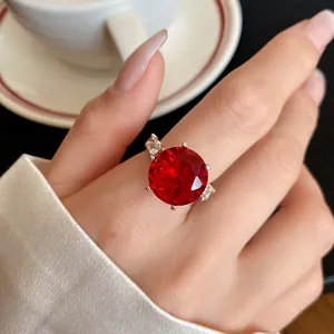Primo piano di un elegante anello argentato con una grande pietra tonda di zircone rosso.
