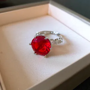 Primo piano di un lussuoso anello d'argento con una grande pietra rossa e zirconi.
