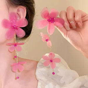 Vista dettagliata degli orecchini a nappa con fiori di chiffon rosa e perle di vetro