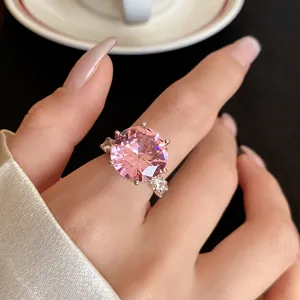 Dettaglio ravvicinato di un grande anello con zircone rosa su una mano ben curata.