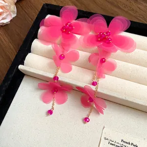 Elegante vista ravvicinata di orecchini a nappa con fiori in chiffon rosa e cristalli