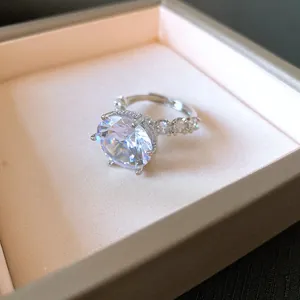 Primo piano di un anello regolabile con zircone tondo in una scatola regalo di lusso
