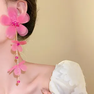 Vista dettagliata degli orecchini a nappa con fiori in chiffon rosa e perle di vetro