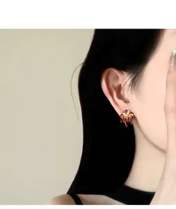 Detailed macro shot of elegant dark red firework stud earring with sparkling zircon