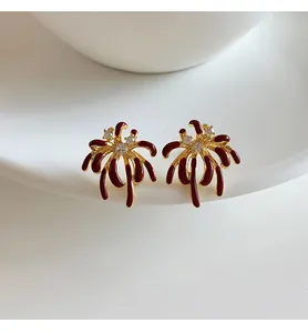 Macro view of detailed firework stud earrings with red enamel and sparkling zircons