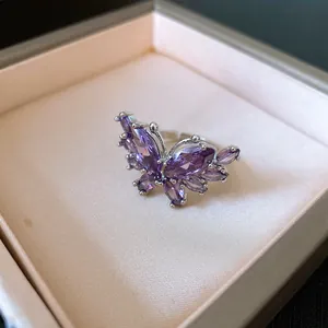 Dettaglio macro di un anello a farfalla con zirconi viola in una scatola regalo di lusso