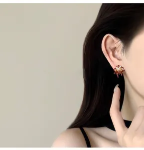 Detailed macro view of 18k gold plated firework earring with red enamel and zircon