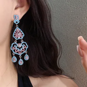 Gros plan de boucles d'oreilles vintage avec perles turquoise et fleurs en strass roses
