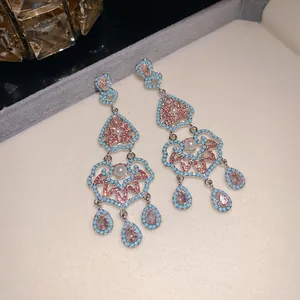 Détail macro de boucles d'oreilles pendantes style palais vintage avec pierres roses