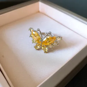 Vista macro di un elegante anello a farfalla in argento con pietre di zircone giallo