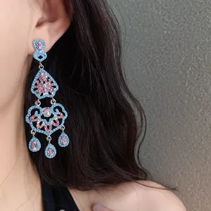 Vue détaillée de boucles d'oreilles pendantes vintage avec cristaux roses et turquoise.