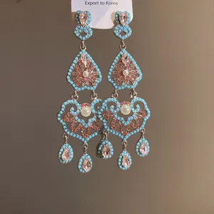 Détail de boucles d'oreilles vintage de style palais avec perles turquoise.