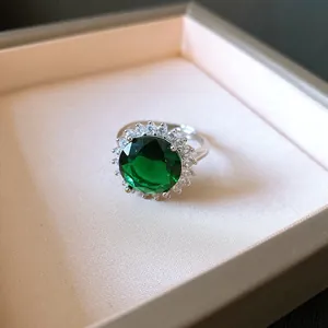 Primo piano di un elegante anello d'argento con pietra verde smeraldo tonda in scatola