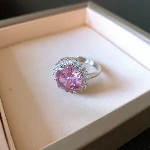 Dettaglio macro di un anello halo con zircone rosa scintillante in una scatola regalo chic