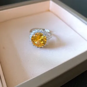 Primo piano di un elegante anello rotondo in zircone giallo con dettaglio halo