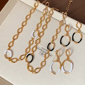 Detailed view of luxury gold-tone jewelry set with black and white enamel accents