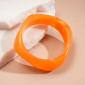 Elegant irregular resin bangle in vibrant orange with unique marbled texture finish