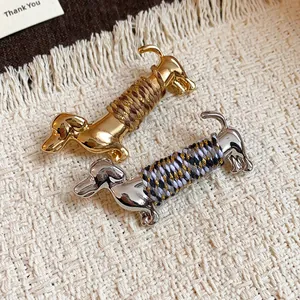 Broches élégantes en forme de teckel avec détails de cordons tissés en doré et argenté