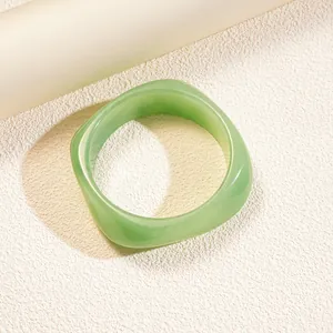 Elegant minimalist light green irregular resin bangle with a smooth polished finish and retro style
