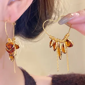 Detailed close-up of vintage 18K gold plated heart earrings with amber teardrop tassels