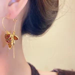 Close-up of 18K gold plated heart earrings with amber charms and tassel detail