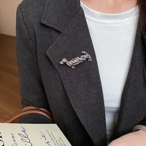 Vue détaillée d'une broche teckel en métal argenté sur le revers d'un blazer sombre chic