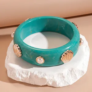 Elegant turquoise marble resin bangle featuring gold shell and pearl decorative studs