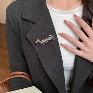 Gros plan d'une broche teckel en métal bicolore de style français sur un blazer.