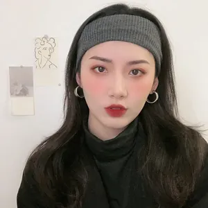 Detailed view of woman wearing elegant silver geometric hoop earrings.