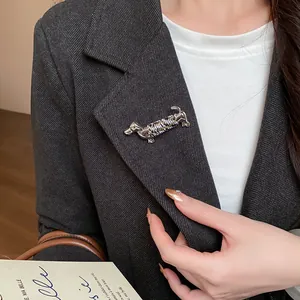 Gros plan sur une broche teckel de style français épinglée sur le revers d'un blazer gris