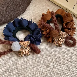 Detailed view of fabric ruffled hair ties featuring flocked leopard print bear charms.