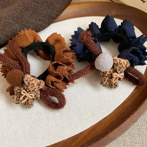 Close-up detail of ruffled fabric hair ties with cute leopard print bear charms
