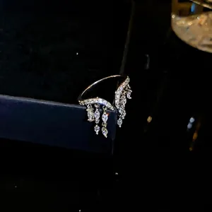 Elegante anillo abierto con borlas de circón, piedras colgantes y diseño de lujo.