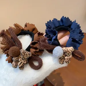 Detail view of ruffle hair scrunchies with plush leopard bear and pom-pom accessory