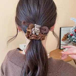Detailed view of brown ruffled hair scrunchie with cute leopard print bear mascot